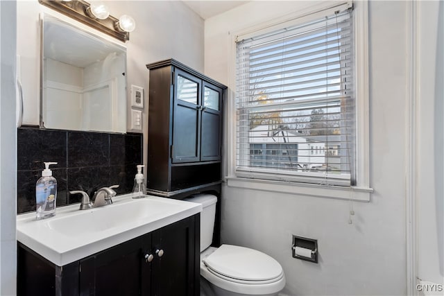 bathroom with vanity, toilet, and backsplash