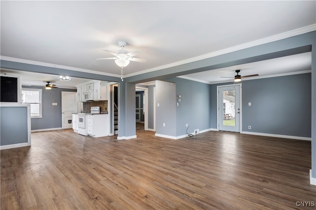 unfurnished living room featuring a wealth of natural light, wood-type flooring, and ornamental molding