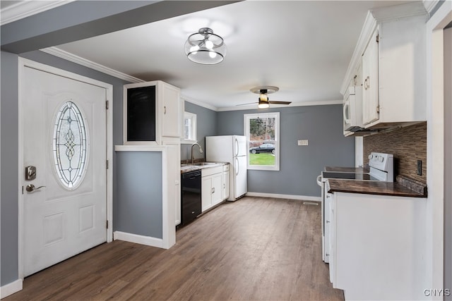 kitchen with white appliances, white cabinetry, sink, and hardwood / wood-style flooring