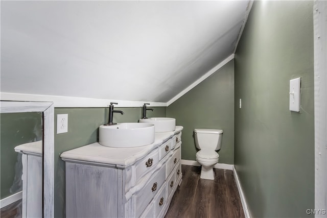 bathroom featuring toilet, vanity, lofted ceiling, and hardwood / wood-style flooring