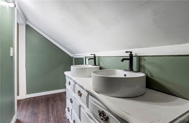 bathroom featuring vanity, hardwood / wood-style floors, and vaulted ceiling