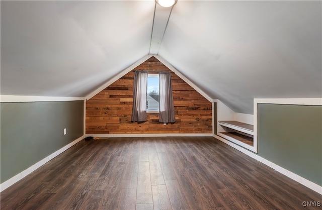 bonus room with wood walls, lofted ceiling, and dark hardwood / wood-style floors