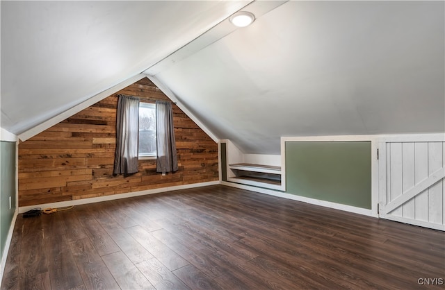 bonus room with wood walls, vaulted ceiling, and dark hardwood / wood-style flooring