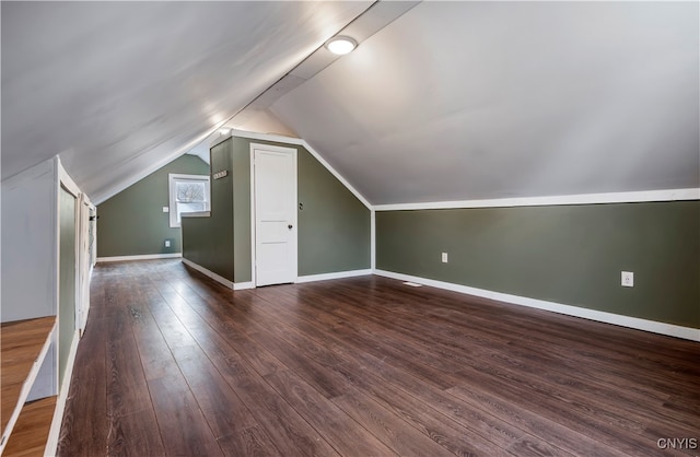 bonus room with vaulted ceiling and dark hardwood / wood-style floors