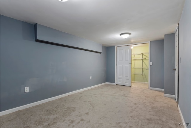 unfurnished bedroom with light colored carpet, a closet, and a walk in closet