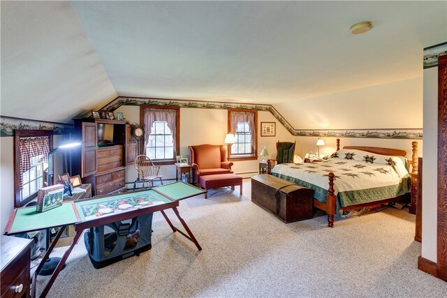 bedroom with a baseboard heating unit, lofted ceiling, and carpet floors