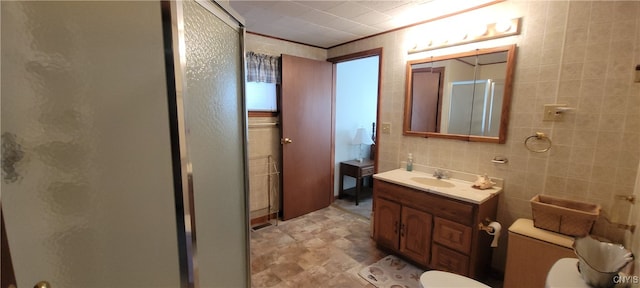 bathroom featuring tile walls, vanity, an enclosed shower, and toilet