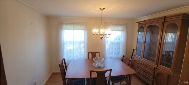 dining room featuring a notable chandelier, crown molding, and wood-type flooring