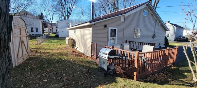 back of house featuring a wooden deck and a lawn