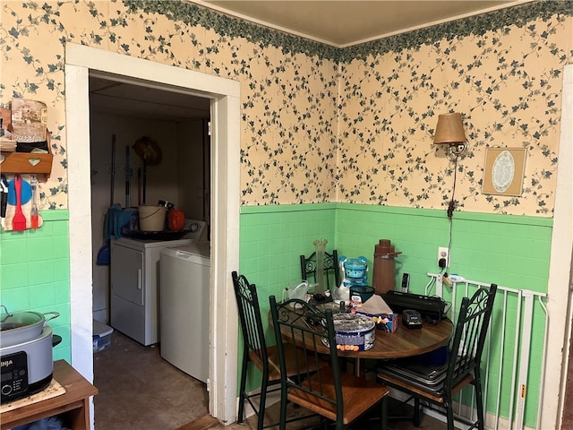 dining room featuring tile walls and washing machine and dryer