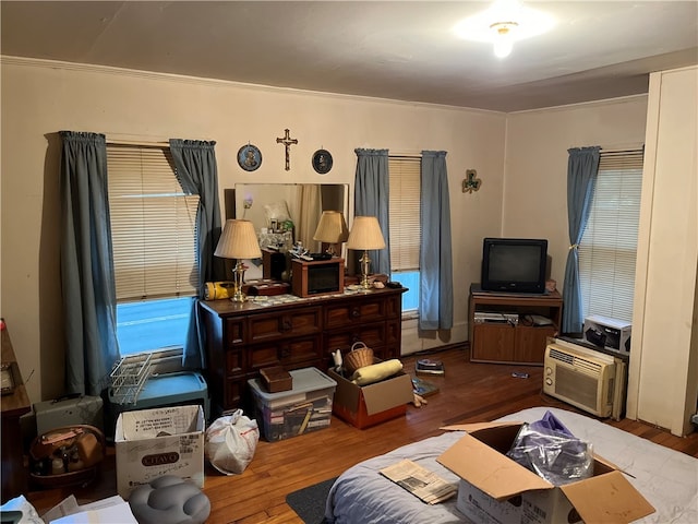 living room with hardwood / wood-style flooring, a wall mounted AC, and ornamental molding