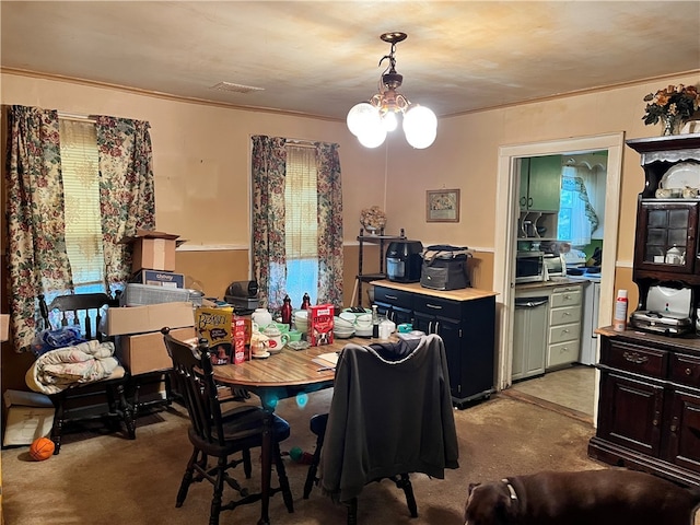 carpeted dining space featuring ornamental molding and a notable chandelier