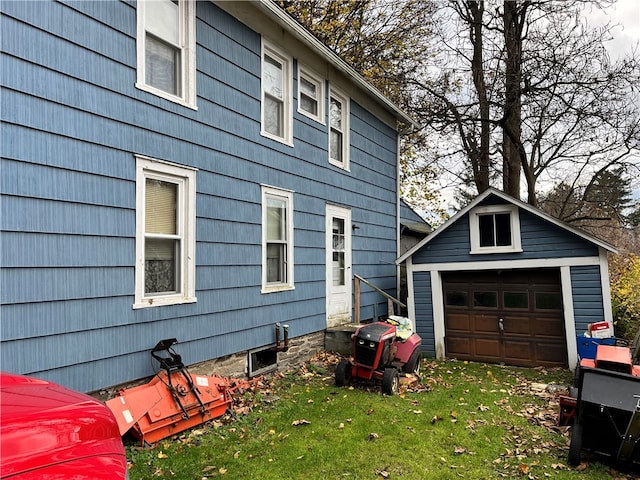 view of side of property with an outbuilding, a garage, and a lawn