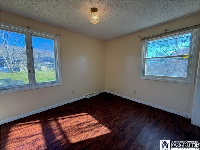 spare room with a textured ceiling and dark hardwood / wood-style floors