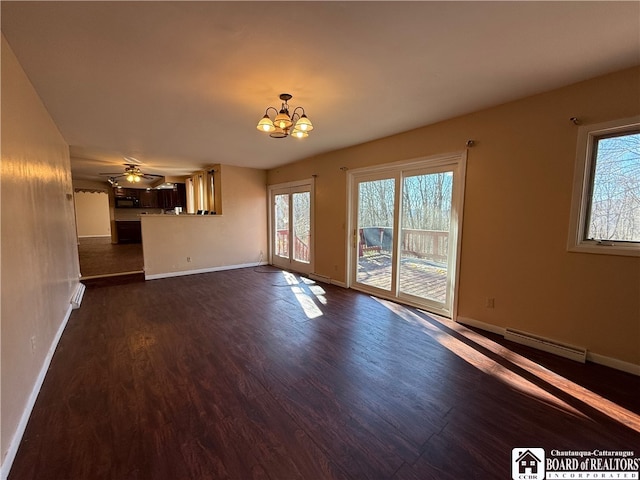 unfurnished living room featuring ceiling fan with notable chandelier, a baseboard radiator, and dark wood-type flooring