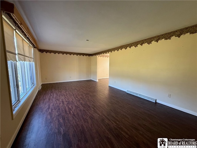 empty room with a baseboard radiator and dark wood-type flooring