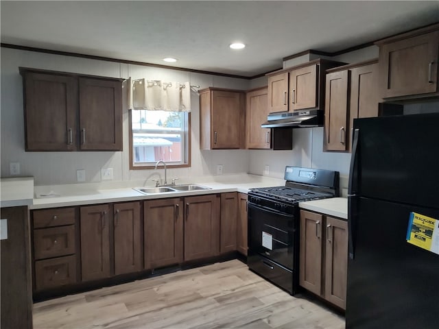 kitchen featuring black appliances, sink, dark brown cabinetry, and light hardwood / wood-style floors