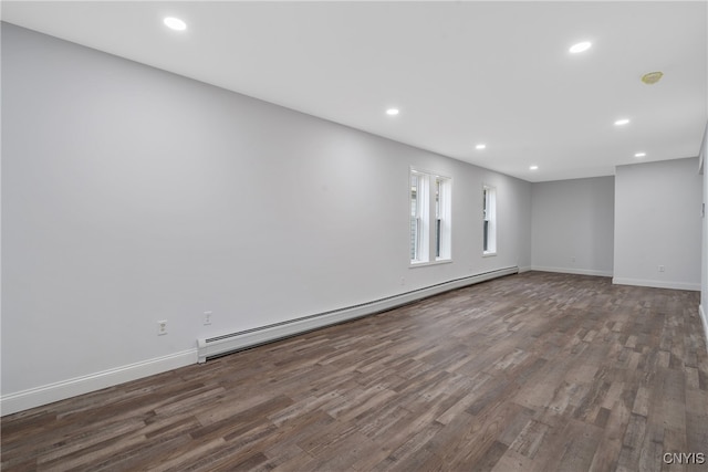 empty room featuring a baseboard radiator and dark wood-type flooring