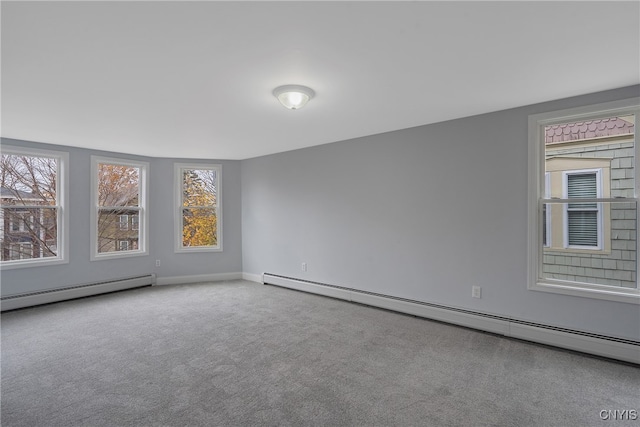 empty room featuring a baseboard heating unit and carpet floors