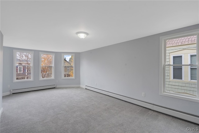 spare room featuring baseboard heating and light carpet