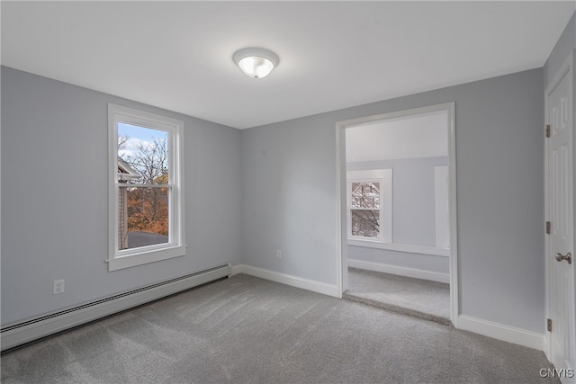 carpeted empty room with baseboard heating