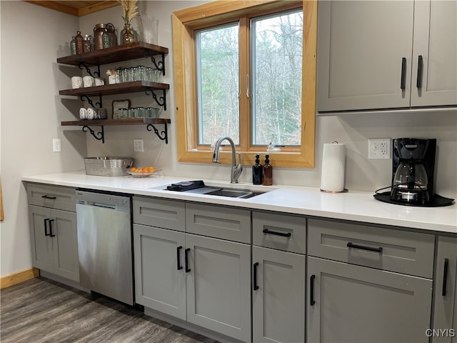 kitchen with gray cabinets, dark hardwood / wood-style flooring, stainless steel dishwasher, and sink