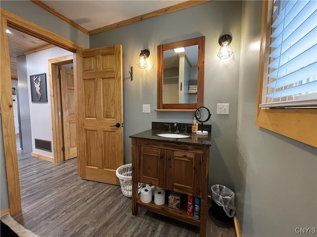 bathroom with hardwood / wood-style flooring, vanity, and crown molding