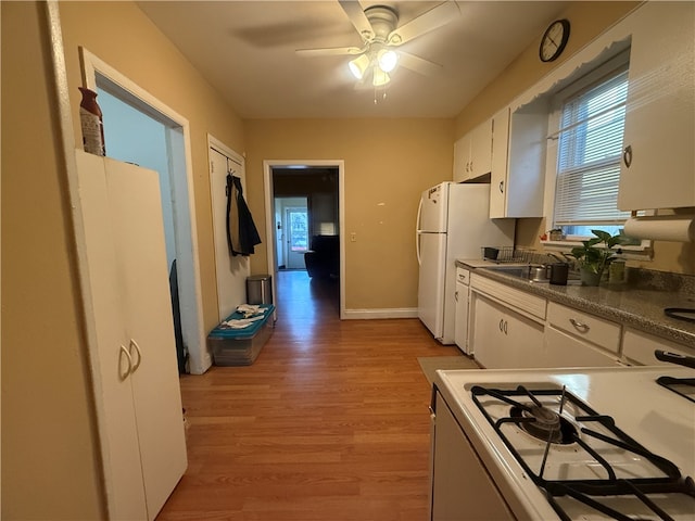 kitchen with sink, light hardwood / wood-style floors, white cabinets, white appliances, and ceiling fan