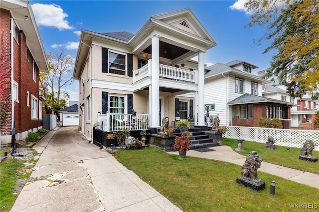 greek revival house featuring a porch, a balcony, an outbuilding, a front lawn, and a garage