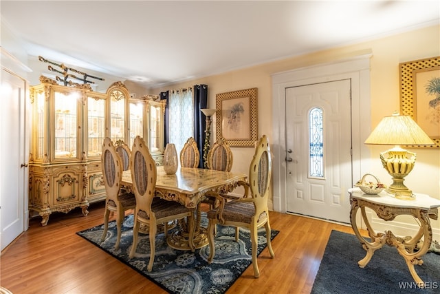 dining room with crown molding and light wood-type flooring