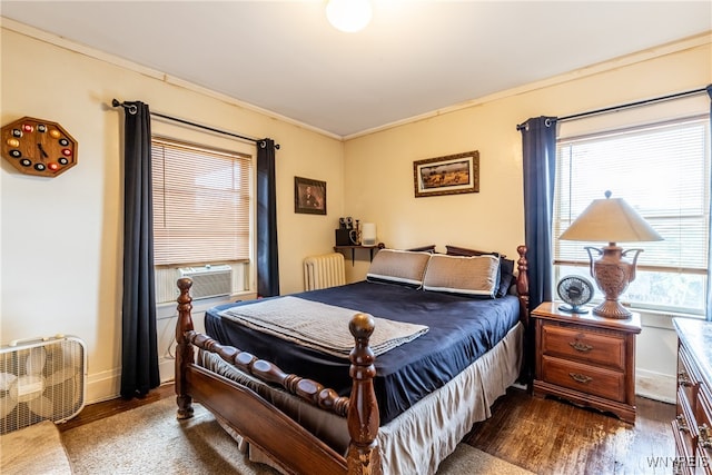 bedroom featuring radiator, cooling unit, dark hardwood / wood-style floors, and ornamental molding