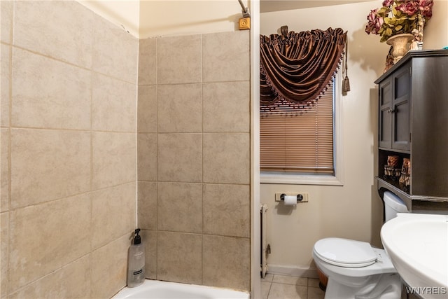 bathroom with tile patterned floors, a bathing tub, toilet, and sink