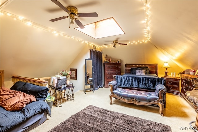 bedroom featuring vaulted ceiling with skylight, ceiling fan, and light carpet