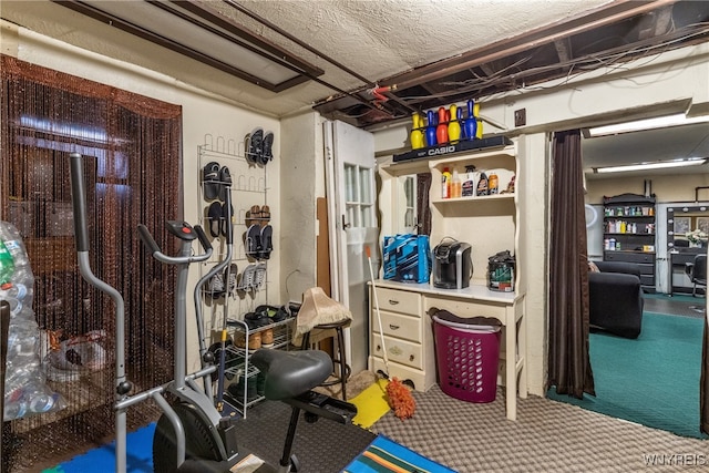 exercise area featuring carpet and a textured ceiling