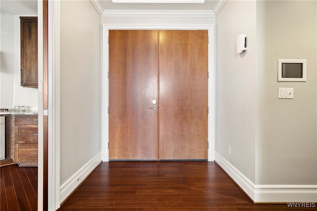 hallway with dark hardwood / wood-style flooring and ornamental molding