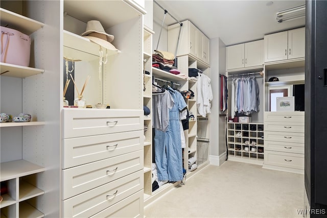 spacious closet featuring light colored carpet