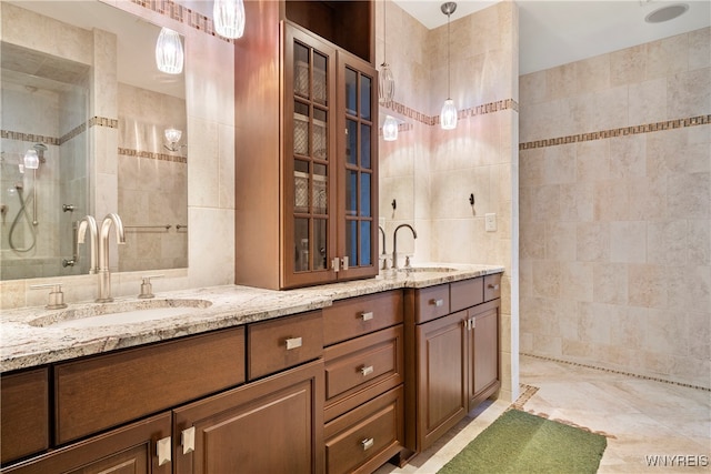 bathroom featuring vanity, a tile shower, and tile walls