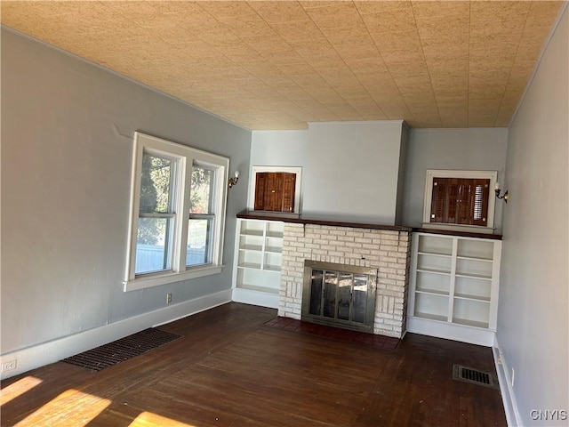 unfurnished living room featuring a fireplace and dark wood-type flooring