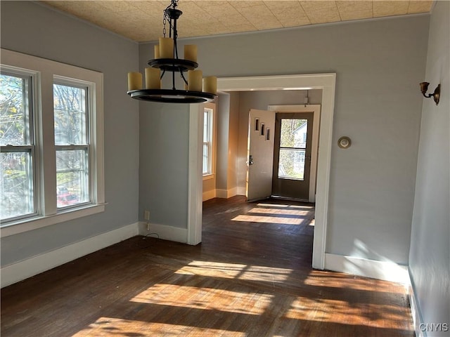 unfurnished dining area with dark hardwood / wood-style floors and a notable chandelier