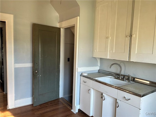 kitchen featuring dark hardwood / wood-style flooring, white cabinetry, and sink