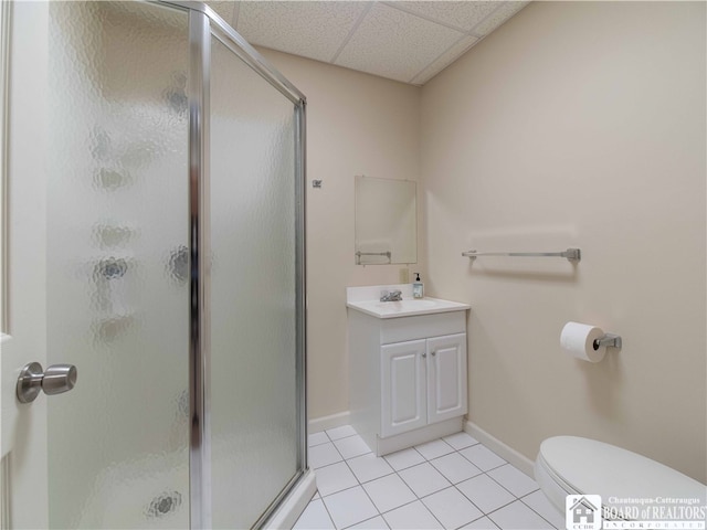 bathroom featuring tile patterned floors, toilet, an enclosed shower, and a drop ceiling