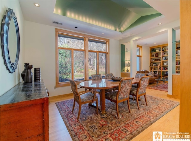 dining room featuring light hardwood / wood-style floors and lofted ceiling