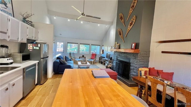 kitchen with a fireplace, light wood-style floors, white cabinets, light countertops, and appliances with stainless steel finishes