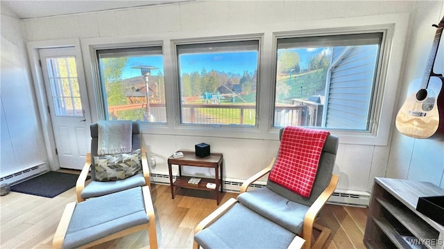 living area featuring baseboard heating and wood finished floors