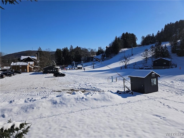 snowy yard with a storage shed