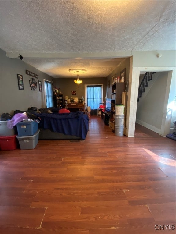 living room featuring hardwood / wood-style floors, a notable chandelier, and a textured ceiling