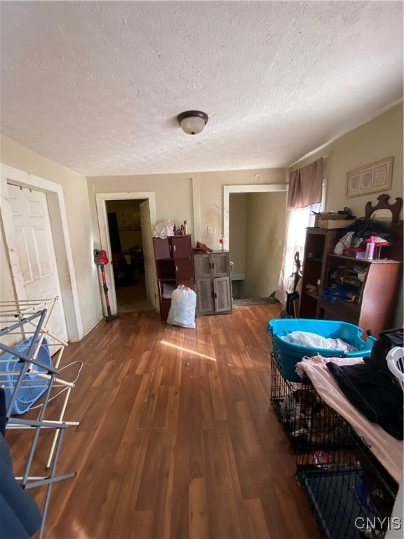 misc room featuring dark wood-type flooring and a textured ceiling