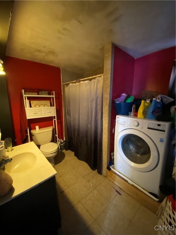 bathroom with a shower with shower curtain, washer / clothes dryer, vanity, tile patterned floors, and toilet