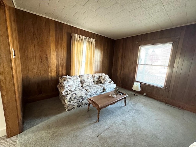 sitting room featuring ornamental molding, light colored carpet, and wooden walls