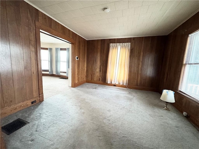 unfurnished room featuring light colored carpet, plenty of natural light, and crown molding